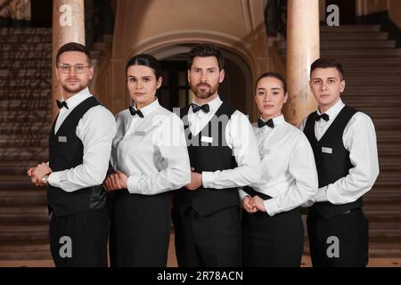 Gruppe von Trainees, die formelle Kleidung im Hotel tragen. Professionelle Butler-Kurse Stockfotografie