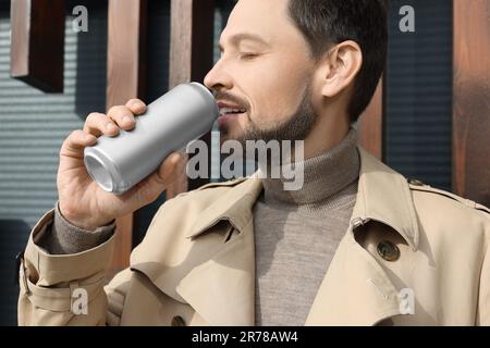 Ein hübscher Mann, der draußen aus der Dose trinkt, Nahaufnahme Stockfoto