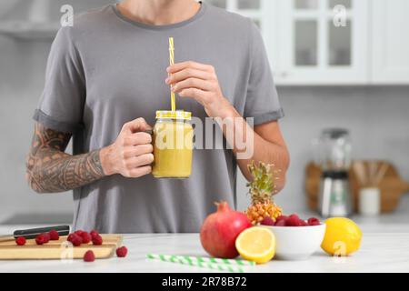 Mann mit leckerem Smoothie in der Küche, Nahaufnahme Stockfoto