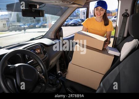 Der Kurier nimmt das Paket vom Auto ab. Lieferservice Stockfoto