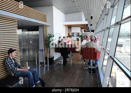 RIGA, LETTLAND - 13. JUNI 2011: Passagiere des Internationalen Flughafens Riga warten auf den nächsten Flug 13. Juni 2011. Der internationale Flughafen von Riga ist einer von Stockfoto