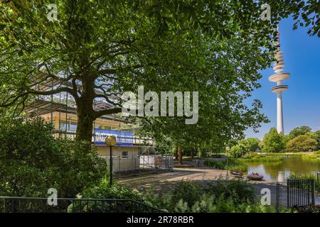 Hamburg, Deutschland. 12. Juni 2023. Blick auf das Café Seeterrassen im Park Planten un Blomen in Hamburg. Der traditionelle Pub mit vier Veranstaltungsräumen und einer 2.000 m² großen Terrasse sowie Gastronomie ist seit 2020 leer. Der geplante Abriss des Cafés, das 1953 nach Plänen des Hamburger Architekten Ferdinand Streb für die Internationale Gartenausstellung gebaut wurde, wurde durch eine Petition verhindert. Jetzt hat der Bezirk Hamburg-Mitte das Café Seeterrassen gekauft. Kredit: Ulrich Perrey/dpa/Alamy Live News Stockfoto