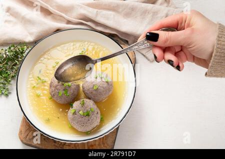 Canederli oder Knodel in Brühe mit grünen Zwiebeln, typischen Nudeln oder Teigtaschen für Alpen, Südtirol, deutsche, italienische und österreichische Küche. Aus altem Ballaststoff Stockfoto