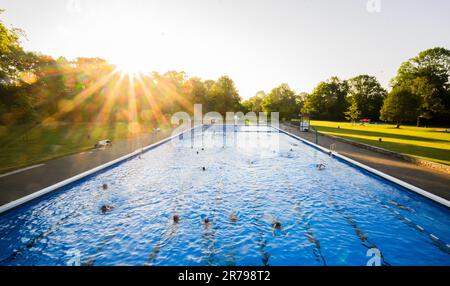 Hannover, Deutschland. 14. Juni 2023. Frühschwimmer schwimmen im Licht der aufgehenden Sonne am Annabad Outdoor Pool. Kredit: Julian Stratenschulte/dpa/Alamy Live News Stockfoto