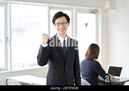 Asiatischer Geschäftsmann, der im Seminarraum seine Faust hält Stockfoto