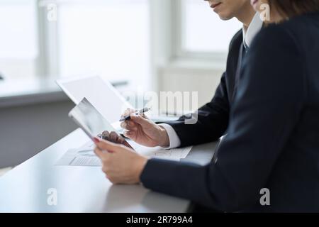 Asiatischer Geschäftsmann, der ein Meeting mit einem Tablet führt Stockfoto