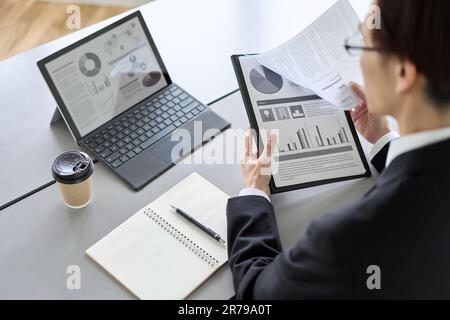 Asiatischer Geschäftsmann, der Marketinganalysen durchführt Stockfoto