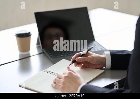 Asiatischer Geschäftsmann, der online am Computer studiert Stockfoto
