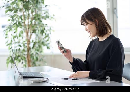 Asiatische Frau, die Steuererklärungen auf dem Smartphone einreicht Stockfoto