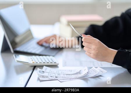 Asiatische Frau, die Spesen in Buchhaltungssoftware eingibt Stockfoto