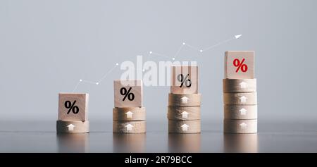 Holzwürfel mit Prozentsymbol, Prozentpfeilen und aufwärts steigenden Pfeilen auf Holzwürfeln schließen. Die Zinssätze für Hypothekarkredite steigen oder der Preis steigt Stockfoto