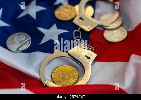 Golden Bitcoins Kryptowährung mit Handschellen auf Dollarscheinen. Konzept der digitalen Kriminalität, der Festnahme oder des Hacking. Handschellen Dollar und Bitcoins auf dem Tisch Stockfoto