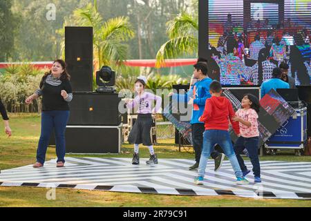 Neu-Delhi, Indien - 10.12.2022 - Kinder tanzen auf der Tanzfläche zu Musik auf der Outdoor-Kinderparty, lustige glückliche Kinder tanzen auf der Outdoor-Kinderparty Stockfoto