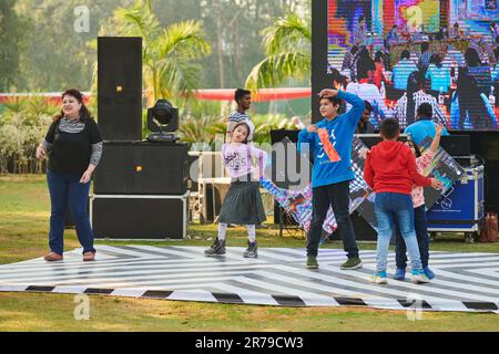 Neu-Delhi, Indien - 10.12.2022 - Kinder tanzen auf der Tanzfläche zu Musik auf der Outdoor-Kinderparty, lustige glückliche Kinder tanzen auf der Outdoor-Kinderparty Stockfoto