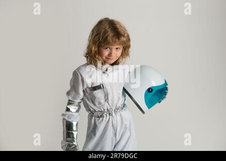 Das kleine Kind will einen Astronauten-Helm im Weltraum tragen. Speicherplatz kopieren. Innovation und Inspiration für Kinder. Stockfoto