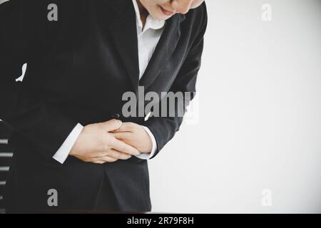 Junge Geschäftsfrau, die unter Magenschmerzen leidet, während sie im Büro arbeitet.Konzept für Gesundheitsprobleme Stockfoto