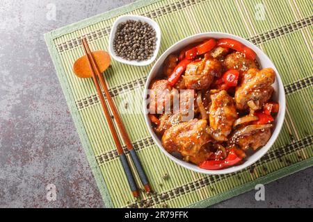 Gebratene Hähnchenteile mit schwarzem Pfeffer, knusprige Zwiebeln und Paprika umrühren, alle mit einer unwiderstehlich köstlichen schwarzen Pfeffersauce auf der Schüssel überzogen Stockfoto