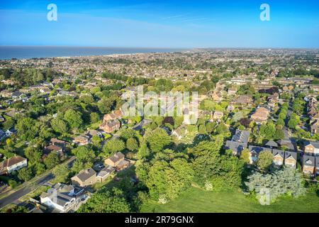 Aus der Luft über die Kirche St. Mary, die Jungfrau auf der Vicarage Road und der Station Road in East Preston und an der Grenze zu Rustington in West Sussex England. Stockfoto