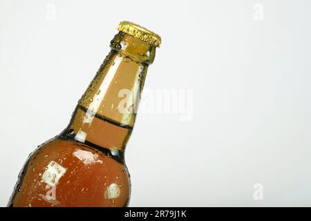 Die Bierflasche auf grauem Hintergrund ist geschlossen. Alkoholarme Getränke Stockfoto