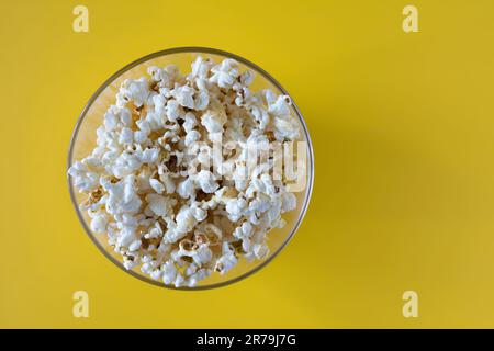 Popcorn von oben auf gelbem Hintergrund. Draufsicht Stockfoto