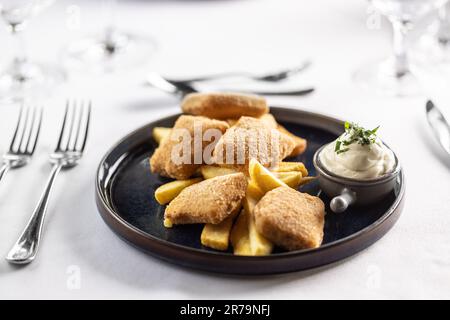 Kindermenü im schicken Restaurant mit Chicken Nuggets und Kartoffelspalten mit Mayonnaise. Stockfoto