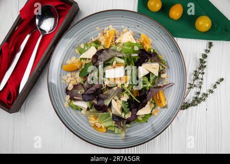 Ein flach liegendes Bild eines Tellers mit Lebensmitteln, einschließlich frischem Gemüse und Obst, im Hintergrund angeordnet Stockfoto