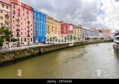 Der Fluss Nervion, sein Ufer und farbenfrohe Wohngebäude auf Martzana Kaia / Muelle de Marzana. Baskenland, Spanien. Stockfoto