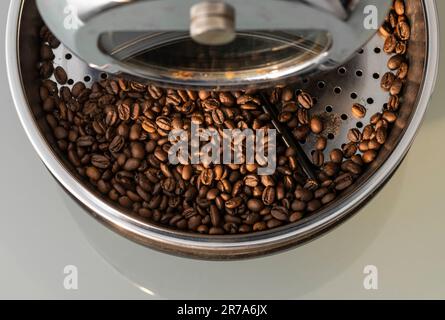 Frisch geröstete Kaffeebohnen in der Kühlschale einer Home-Kaffeeröster mit Ablagefläche. Stockfoto