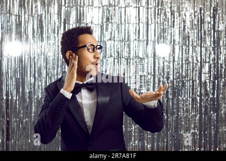 Komischer, fröhlicher Schwarzer im Anzug, der auf einer Disco-Party tanzt, wie DJ, der Musik mischt Stockfoto