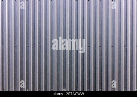 Die Struktur des Zauns aus grauem Profilblech. Hintergrund. Platz für Text. Stockfoto