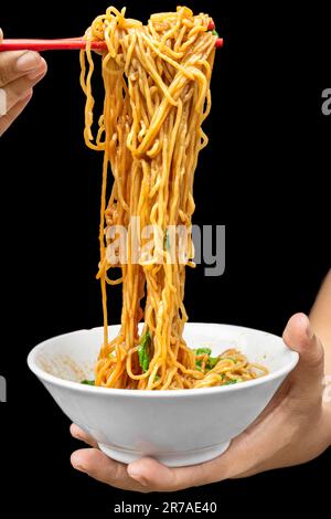 Hähnchennudeln (Mie Ayam) auf schwarzem Hintergrund. Traditionelles indonesisches Essen Stockfoto