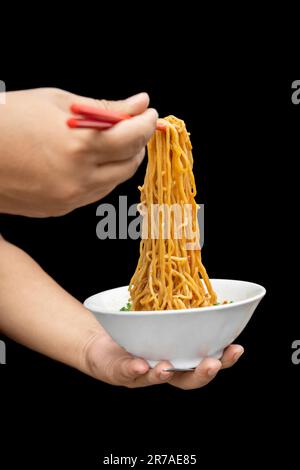 Hähnchennudeln (Mie Ayam) auf schwarzem Hintergrund. Traditionelles indonesisches Essen Stockfoto