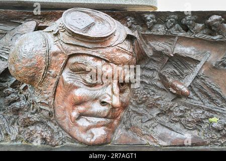 Geformtes helmiges Gesicht eines Flugzeugpiloten auf dem Denkmal zur Schlacht von Großbritannien an der Themse, London, England. Stockfoto