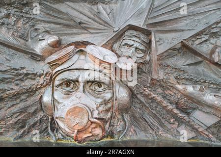 Geformtes helmiges Gesicht eines Flugzeugpiloten auf dem Denkmal zur Schlacht von Großbritannien an der Themse, London, England. Stockfoto