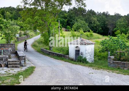 Radfahrerinnen auf einer Radtour durch die Istrien-Halbinsel in Slowenien, Radfahren, vorbei an Weinbergen, kleine Kapelle in der Nähe des Abitanti-Dorfes, slowenien Stockfoto