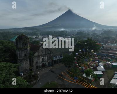 Camalig, Bicol, Philippinen. 14. Juni 2023. Rauch aus Mt. Vulkan Mayon am frühen Morgen des 14. Juni 2023, wie auf der alten Kirche Camalig, Albay, Philippinen zu sehen. Das Pinangat-Festival von Camalig wurde aufgrund des Mt. Mayon-Ausbruch. (Kreditbild: © Sherbien Dacalanio/Pacific Press via ZUMA Press Wire) NUR REDAKTIONELLE VERWENDUNG! Nicht für den kommerziellen GEBRAUCH! Stockfoto