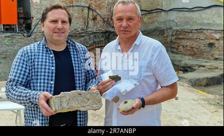 Brandenburg, Deutschland. 14. Juni 2023. Archäologe Torsten Trebes (l) und Baumeister Sven Rohde (r) präsentieren die Funde, einschließlich eines einzigartigen Steins mit dem Datum 1612. Während archäologischer Ausgrabungen in Brandenburg an der Havel sind Forscher auf bis zu 700 Jahre alte Silbermünzen gestoßen. Kredit: Cevin Dettlaff/dpa/Alamy Live News Stockfoto