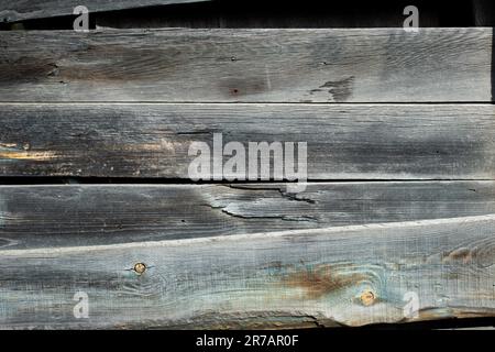 Verwitterte Holzbretter strukturieren den Hintergrund mit horizontalen Platten. Alte Holzbohlen Wand. Unlackiertes graues Rohbrett. Stockfoto