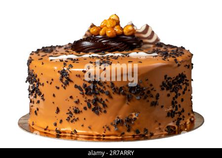 Karamellcremekuchen isoliert auf weißem Hintergrund. Geburtstag oder Feier. Pistazien, Schokolade, Karamell und Sahnekuchen Stockfoto