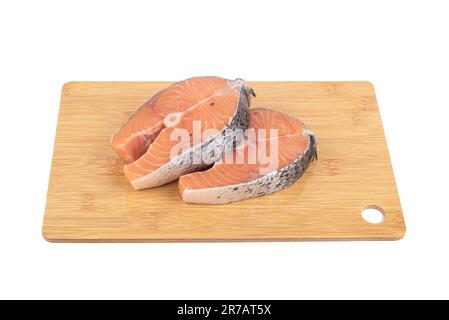 Zwei Lachssteaks auf einem Holzbrett auf weißem Hintergrund. Speicherplatz kopieren. Stockfoto