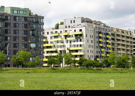 Gemütliches Wiener Viertel in Österreich - Neue, moderne, farbenfrohe europäische mehrstöckige Häuser unter Bäumen. Stockfoto