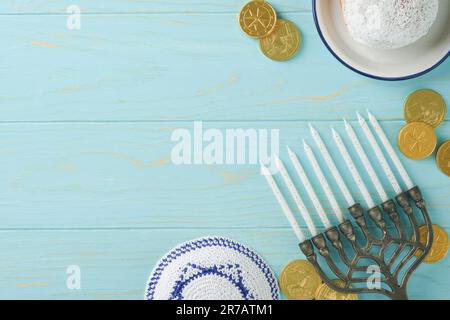 Frohes Chanukka. Chanukka altes Menorah vor dem Hintergrund der israelischen Flagge mit Sonnenlicht oder Bokeh auf weißem Holzhintergrund. Religionsbild der juden Stockfoto