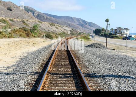 Leere Eisenbahnstrecke entlang einer Küstenstraße in Kalifornien an einem sonnigen Herbsttag Stockfoto