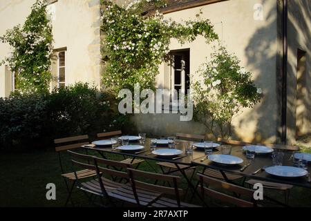 Tisch zum Abendessen im Garten des wunderschönen Ferienhauses aus dem 17. Jahrhundert, Sommer, l'Essonne, Île-de-France, Frankreich Stockfoto