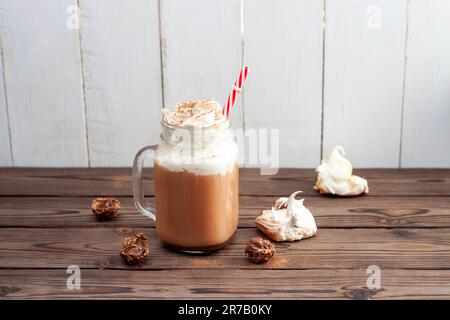 Heißer Kakao mit Schlagsahne, Baiser, Schokoladentrüffel. Erholungsgetränk für kalte Herbst- oder Winterabende Stockfoto