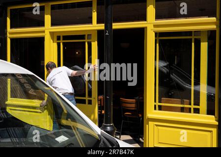 Ein Mitarbeiter öffnet am 14. Juni 2023 die Türen und Fenster eines Restaurantunternehmens in Soho in London, England. Stockfoto