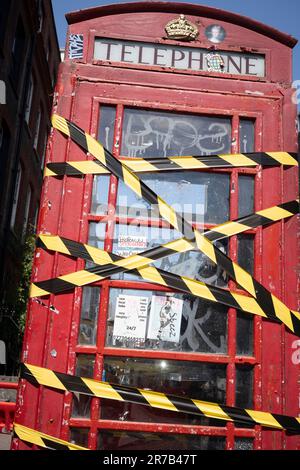 Am 14. Juni 2023 in London, England, ist ein Klebeband um die Türen einer alten Telefonzelle in der Dean Street in Soho gewickelt. Stockfoto