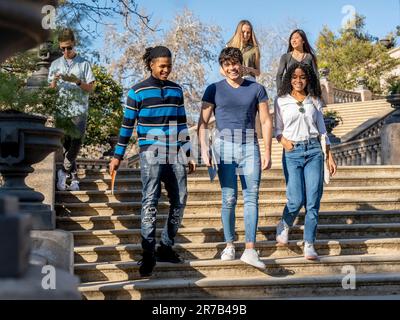 Eine Gruppe junger Studenten, die auf einer Treppe laufen Stockfoto