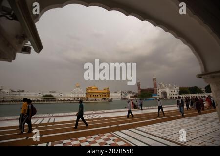 AMRITSAR, 14. Juni 2023 (Xinhua) -- Besucher gehen auf dem Gelände des Goldenen Tempels, während vor dem Monsun Wolken über dem Amritsar Bezirk des nördlichen indischen Bundesstaates Punjab zu sehen sind, 14. Juni 2023. (Str/Xinhua) Stockfoto