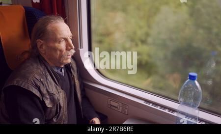 Warschau, Polen. 11. Juni 2023. Die Nahaufnahme eines älteren Mannes mit Brille reist in einem Zug und schaut aus dem Fenster (Kreditbild: © Andrey Nekrasov/ZUMA Press Wire) NUR REDAKTIONELLE VERWENDUNG! Nicht für den kommerziellen GEBRAUCH! Stockfoto